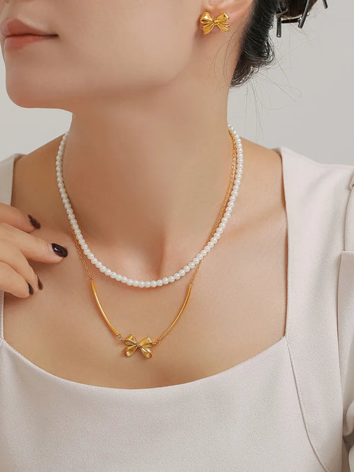 Elegant 3-piece jewelry set with synthetic pearls, gold-plated bow necklace, and titanium steel earrings